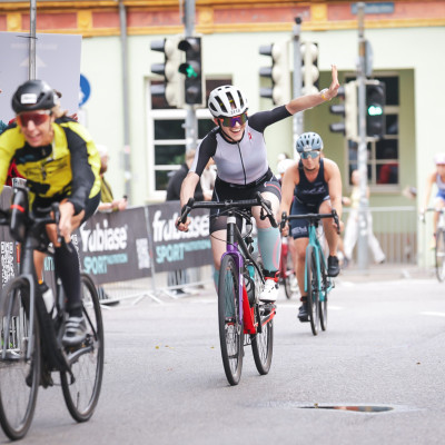 Fahrradfahrer winken zu den Zuschauern